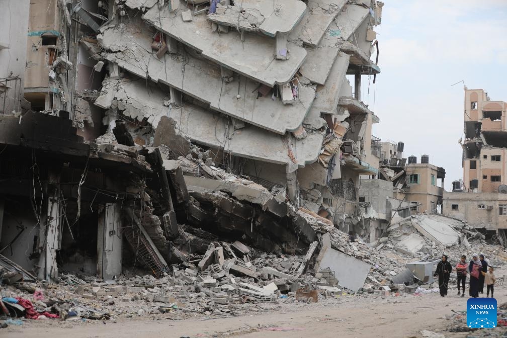 People walk past destroyed buildings in Gaza City, April 8, 2024.(Photo: Xinhua)