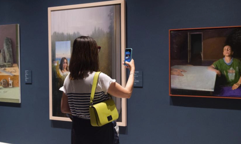 A visitor takes photos at an exhibition featuring contemporary oil paintings from China and Spain at Palacio Real, in Madrid, Spain, on April 12, 2024. (Photo by Gustavo Valiente/Xinhua)