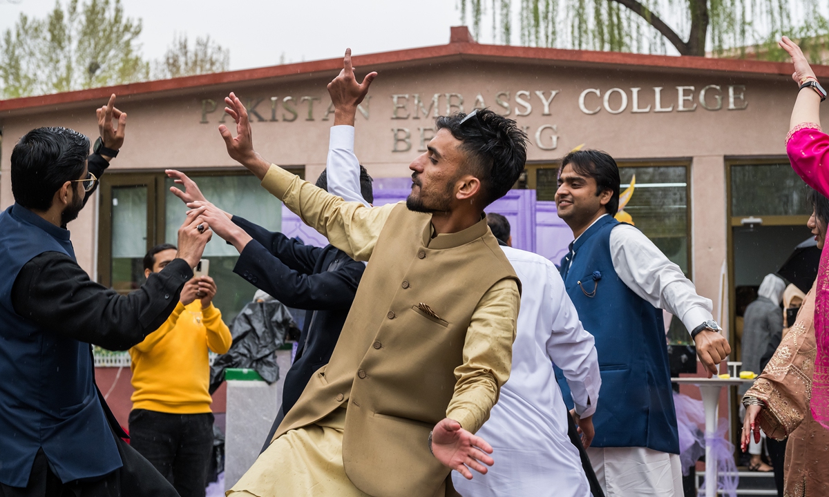 Event participants dance in the light rain on Wednesday. Photo: Chen Tao/GT