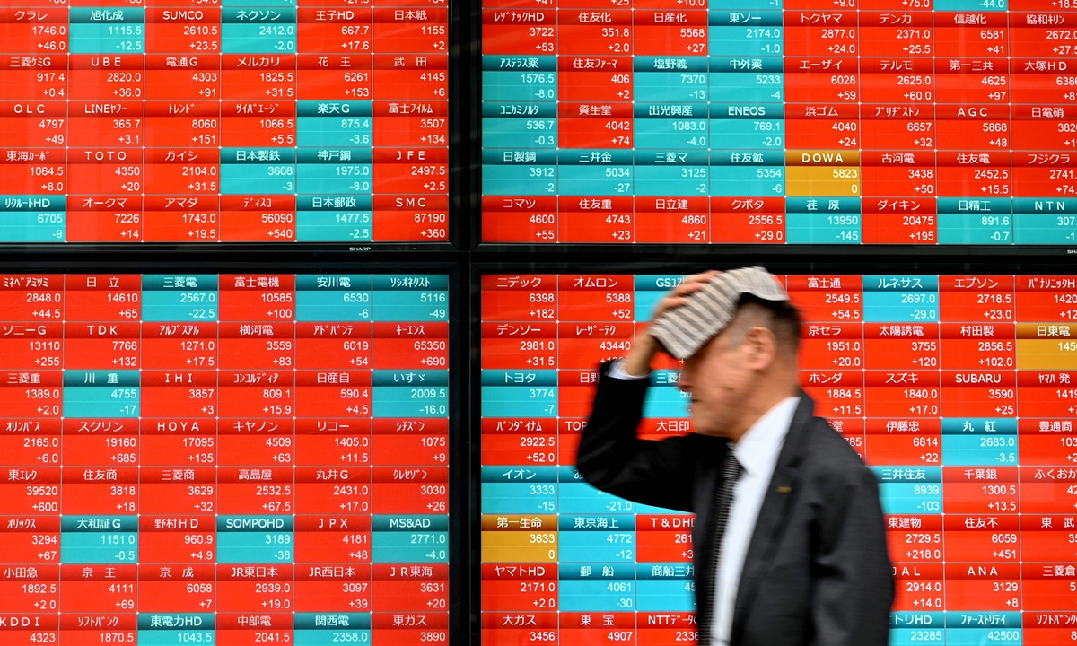 A man walks past an electronic board displaying stock prices of Nikkei 225 listed on the Tokyo Stock Exchange along a street in Tokyo on April 12, 2024. Yen, the Japanese currency, fell nearly one percent to 153.24 against the dollar on April 10, the weakest level since 1990, according to media report. Photo: VCG