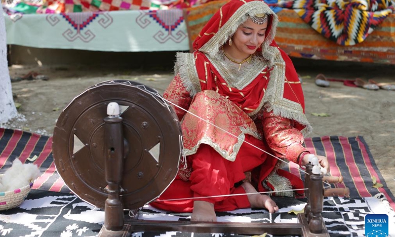 A woman wearing traditional Punjabi attire works on a spinning wheel during a fair celebrating the Baisakhi festival at a college in Amritsar district of India's northern Punjab state, April 9, 2024. Baisakhi is one of the most popular festivals celebrated in the Indian state of Punjab to mark the harvest.(Photo: Xinhua)