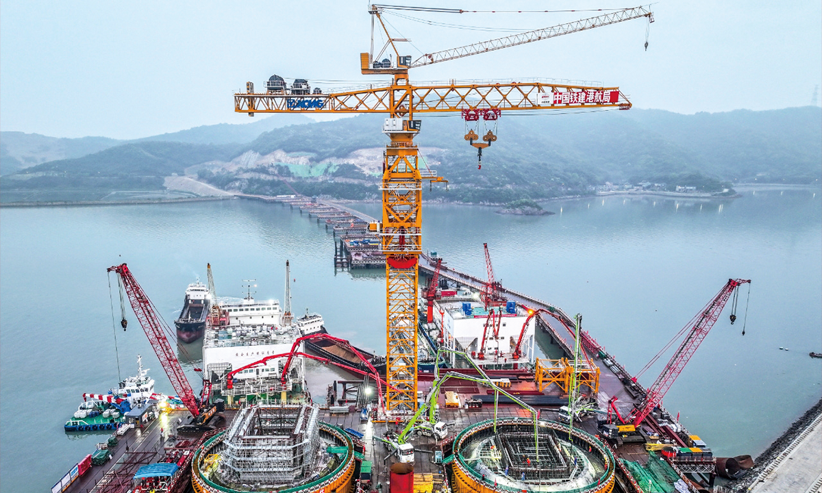 Construction workers are busy at the Shuangyumen Bridge at Ningbo Zhoushan Port in East China's Zhejiang Province on April 16, 2024. After completion, the bridge will claim the title of the world's longest single-span steel box girder suspension bridge and the longest sea-crossing bridge in China. Photo: cnsphoto