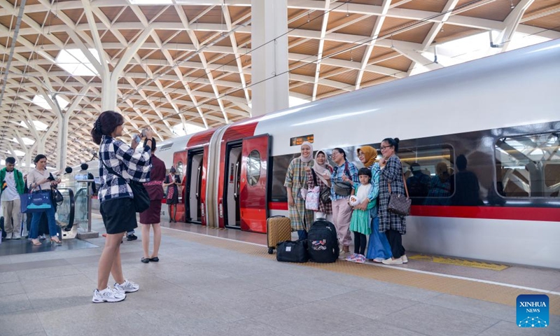 Passengers pose for photos with a high-speed electrical multiple unit (EMU) train of the Jakarta-Bandung high-speed railway on the platform of Halim Station in Jakarta, Indonesia, April 17, 2024. The Jakarta-Bandung High-Speed Railway marked its six months of operation on Wednesday with a total of 2.56 million passengers transported, said PT Kereta Cepat Indonesia-China (KCIC), a joint venture consortium between Indonesian and Chinese state-owned firms that constructs and runs the HSR.(Photo: Xinhua)