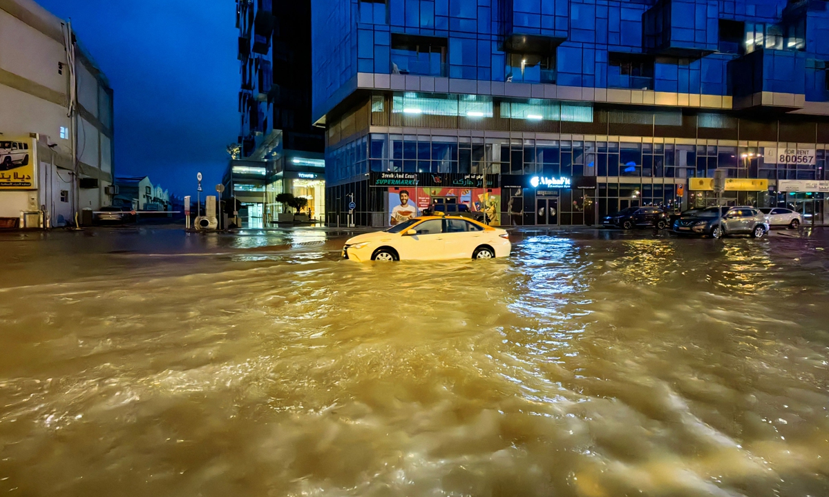 A taxi drives through a flooded street following heavy rains in Dubai on April 17, 2024. Photo: VCG