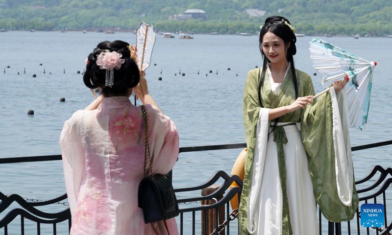 Tourists donning traditional Hanfu attire visit the West Lake in Hangzhou, east China's Zhejiang Province, April 18, 2024.(Photo: Xinhua)