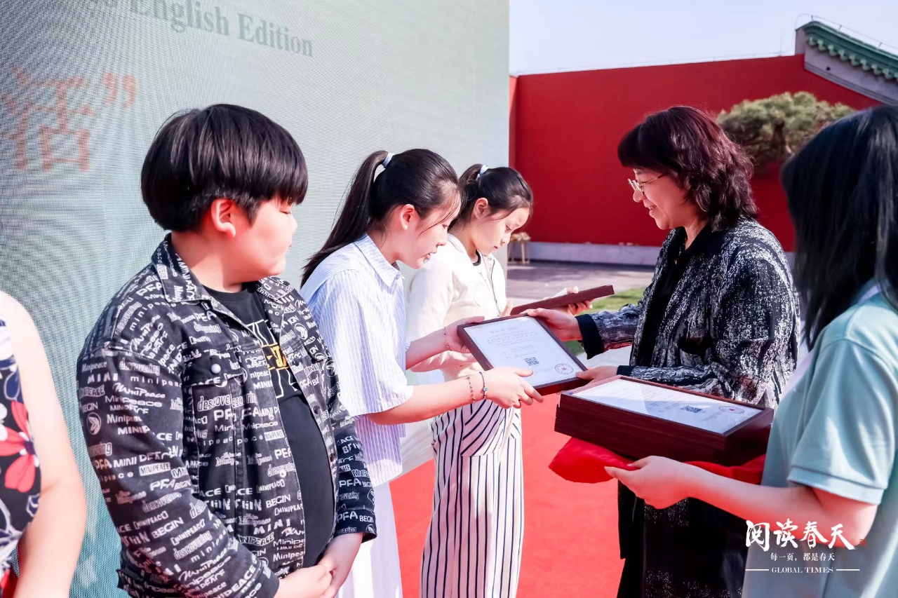 Students receive their certificate for contributing to the Global Times at the event.