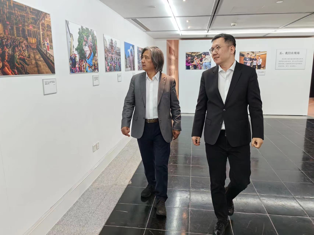 Wu Weishan (left) takes a look at an exhibition of the 15th anniversary of the Global Times English Edition with Global Times Editor-in-Chief Fan Zhengwei (right).