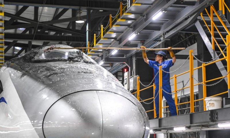 A staff member cleans the body of a bullet train at a train maintenance workshop in Nanning City, south China's Guangxi Zhuang Autonomous Region, May 1, 2024. International Workers' Day is observed annually on May 1. (Xinhua/Cao Yiming)