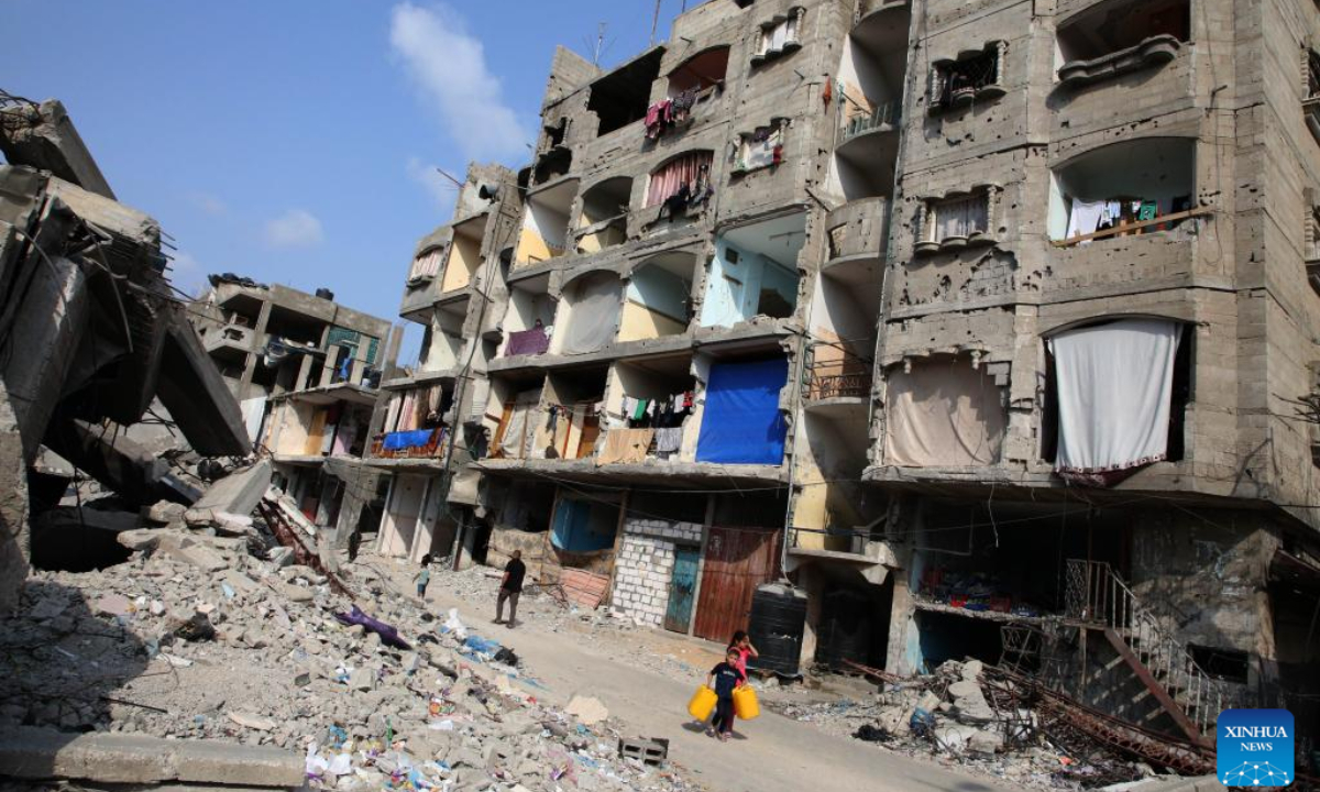 People walk past the rubble of a destroyed building in the southern Gaza Strip city of Rafah, on May 1, 2024. Photo:Xinhua