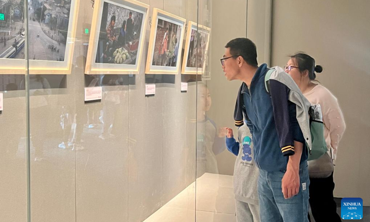 Visitors view photos exhibited at a photography exhibition named 