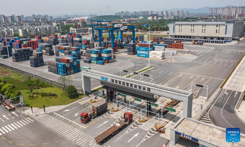 An aerial drone photo taken on May 5, 2024 shows trucks running at the dry port of the New International Land-Sea Trade Corridor in southwest China's Chongqing Municipality. The Chongqing International Logistics Hub Park, which includes the Tuanjiecun Station, the dry port of the New International Land-Sea Trade Corridor, and the Chongqing Railway Port, has risen to be a major hub of international freight trains in the country's western region.(Photo: Xinhua)