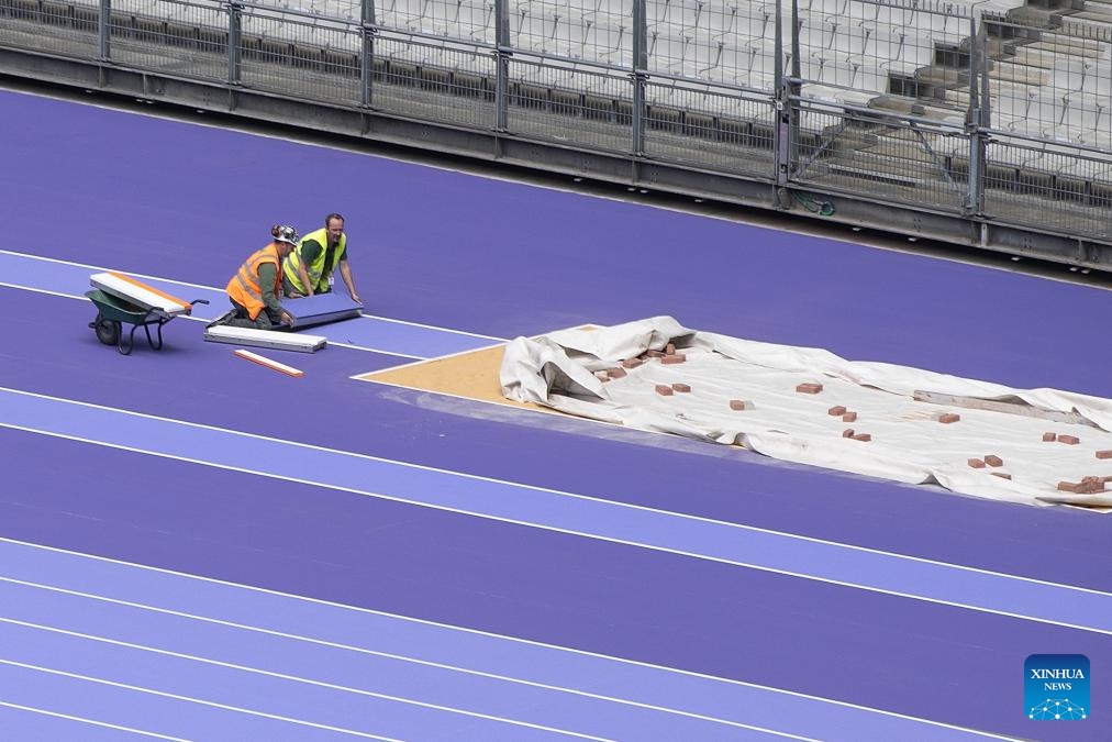 Workers adjust the purple track of the Stade de France, in Paris, France, on May 7, 2024.(Photo: Xinhua)