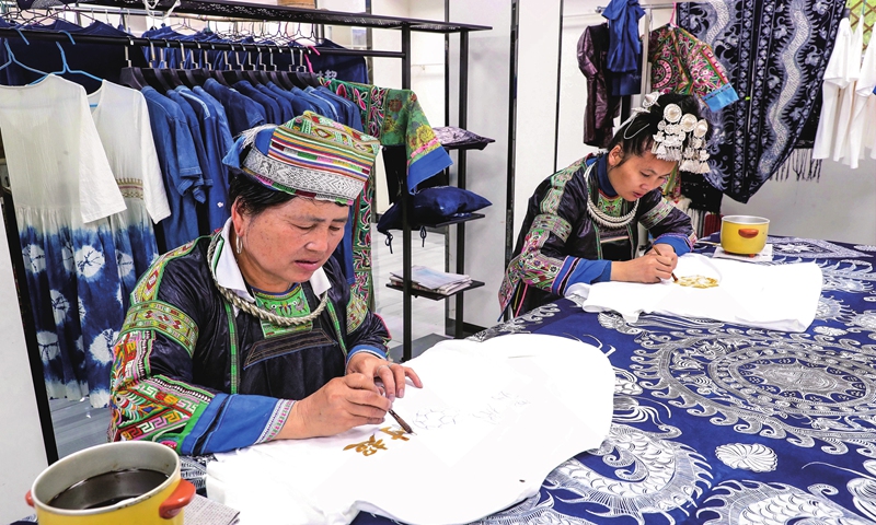 Two Miao women catch up on orders for batik, a craft inherited through generations among the Miao ethnic group, in Rongjiang county, Southwest China's Guizhou Province on May 8, 2024. Local authorities have been promoting the integration of the traditional art with fashion items, aiming to increase the incomes of local residents. Photo: VCG