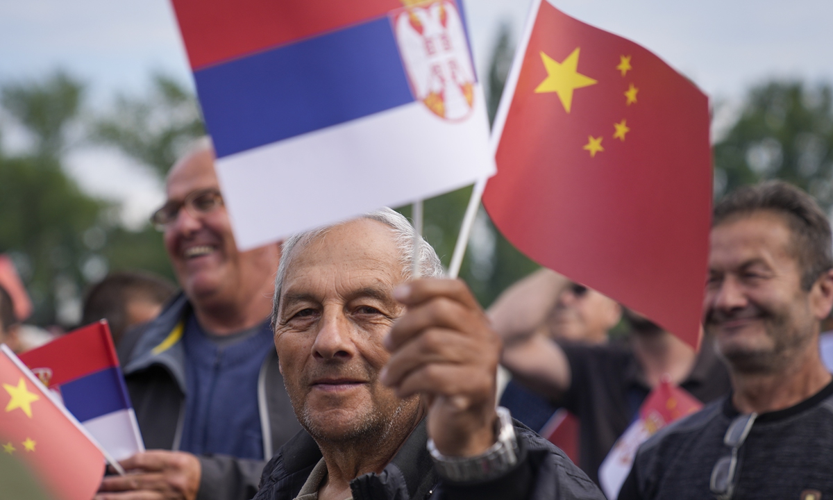 A man (center) waves Chinese and Serbian flags as he waits for the arrival of Chinese President Xi Jinping and his Serbian counterpart Aleksandar Vucic outside the Serbia Palace in Belgrade, Serbia, on May 8, 2024. Photo: VCG 