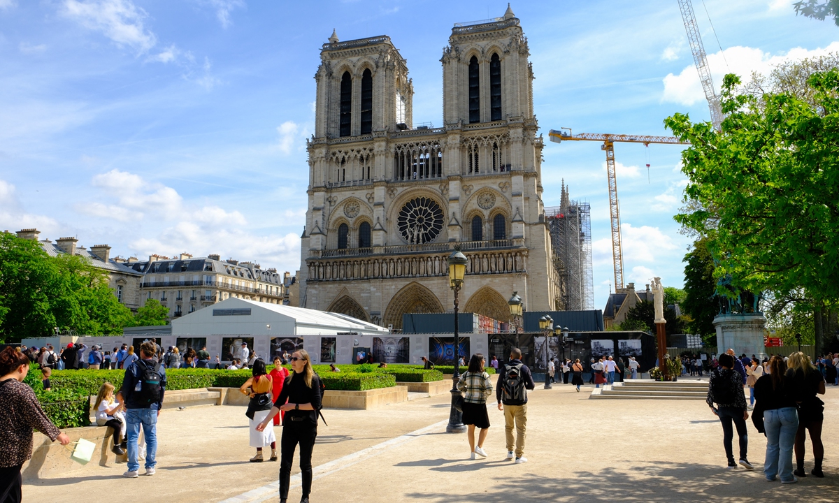 Tourists enjoy themselves in front of the Notre Dame in Paris, France. Photo: VCG