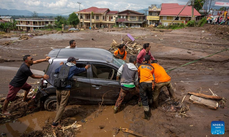 People try to remove a damaged car after a cold lava flood at Agam regency in West Sumatra, Indonesia, on May 12, 2024. The death toll from lava floods that struck Indonesia's West Sumatra province on Saturday rose to 34, with at least five others missing, a senior official of the local disaster agency said on Sunday. Photo: Xinhua