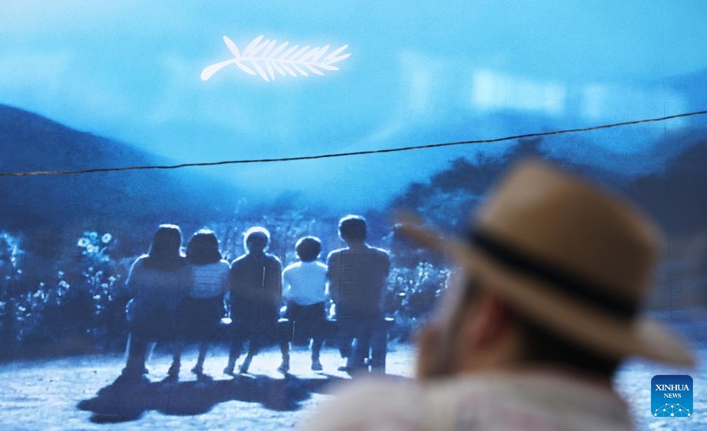 A man walks past a huge poster of the 77th edition of the Cannes Film Festival outside the Palais du Festival in Cannes, southern France, May 13, 2024. This year's festival runs from May 14 to 25.(Photo: Xinhua)