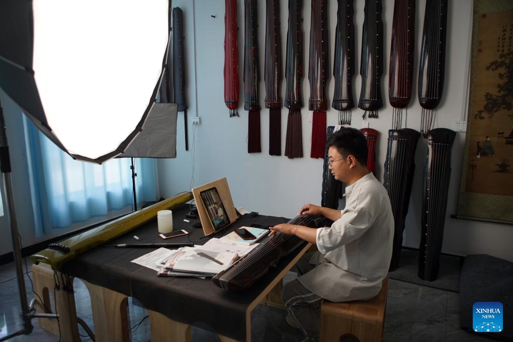 Instrument maker Xu Bing sells guqin, a plucked seven-string traditional Chinese musical instrument, via livestreaming in Lankao County of Kaifeng City, central China's Henan Province, May 13, 2024. In recent years, Lankao County has vigorously developed the traditional musical instrument industry in an effort to fully utilize paulownia trees, which are bountiful in the county.(Photo: Xinhua)