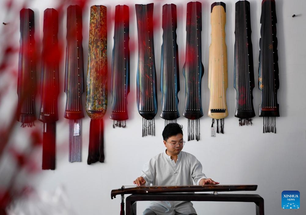 Instrument maker Xu Bing plays guqin, a plucked seven-string traditional Chinese musical instrument, at home in Lankao County of Kaifeng City, central China's Henan Province, May 13, 2024. In recent years, Lankao County has vigorously developed the traditional musical instrument industry in an effort to fully utilize paulownia trees, which are bountiful in the county.(Photo: Xinhua)