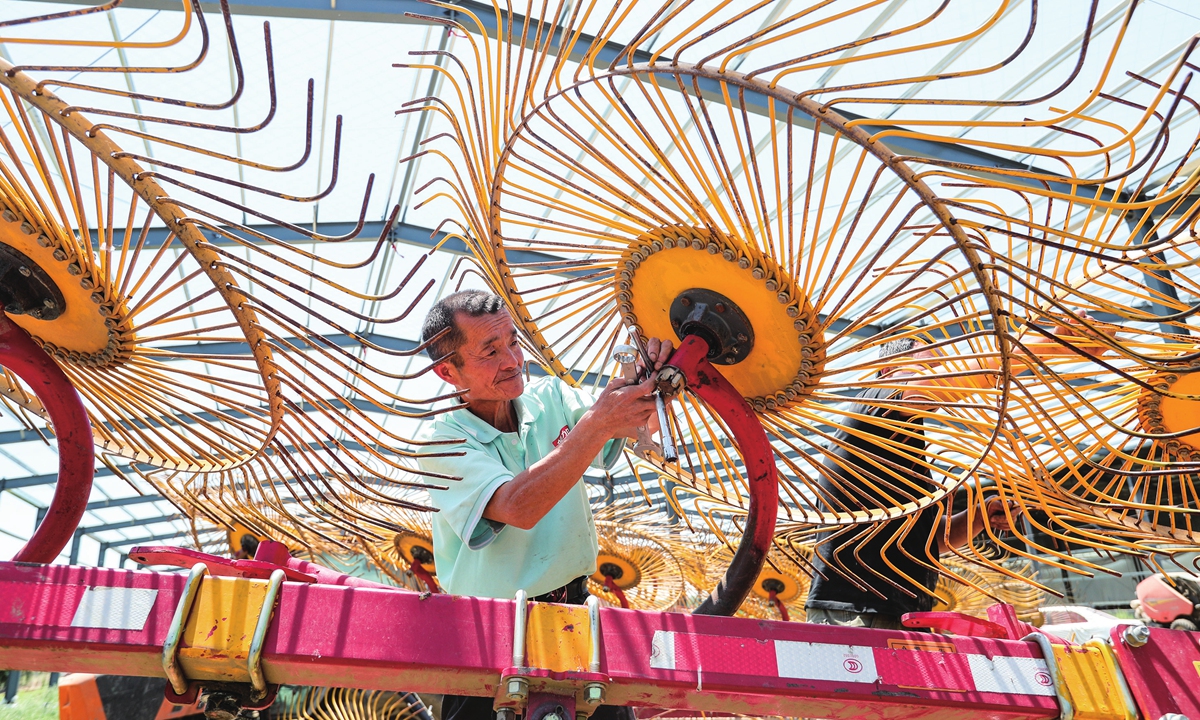 A farmer overhauls raking machines in in Mengcheng county, East China's Anhui Province on May 16, 2024, in order to be fully prepared for the upcoming wheat harvest. More than 1.9 million mu (126,667 hectares) of wheat is expected to be harvested in the county, and 54,000 units of farm  machinery will be put into operation. Photo: VCG