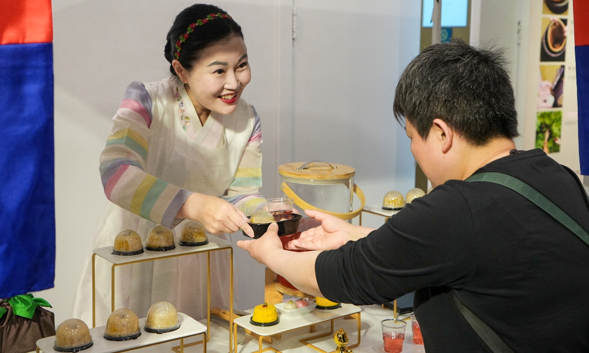 A visitor tastes traditional Korean snacks at the exhibition on May 16, 2024. Photo: Lu Ting/GT 