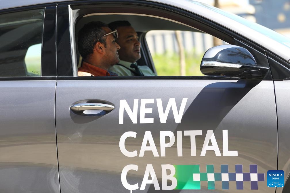 People experience an electric taxi during a pilot program ceremony in New Administrative Capital, Egypt, on May 15, 2024. Egypt kicked off the pilot program on Wednesday for operating the country's first fleet of electric taxis in its newly-built New Administrative Capital (NAC), aiming to provide eco-friendly and smart transportation options.(Photo: Xinhua)