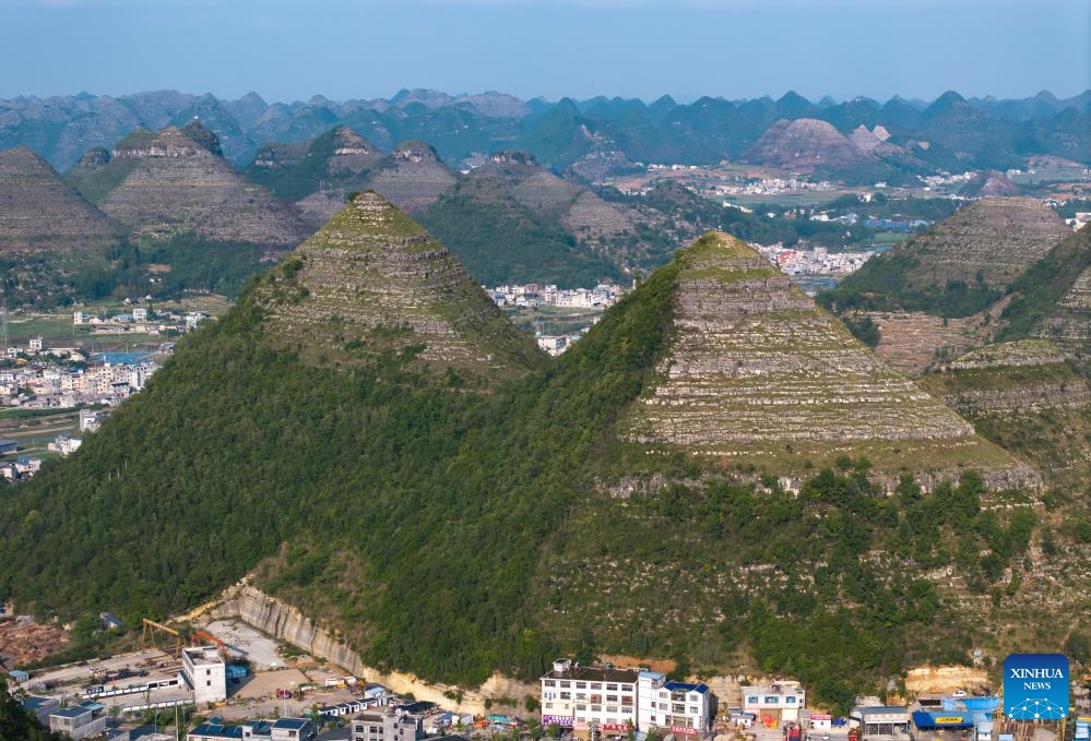 An aerial photo taken on May 14, 2024 shows a view of pyramid-shaped hills in Anlong County, southwest China's Guizhou Province. Several hills that resemble the pyramids of Egypt in a suburb of Anlong have recently become a popular tourist attraction. It appears that these hills are made of parallel layers of stones.(Photo: Xinhua)