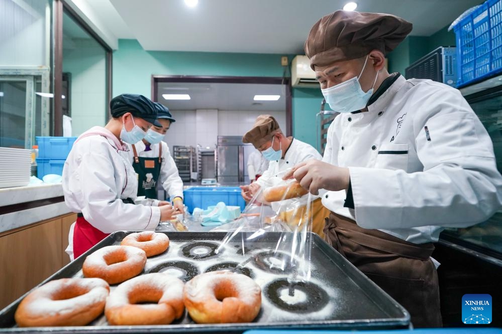 Fu Fu (1st R) and his colleagues pack up bread at Amity Bakery in Nanjing, east China's Jiangsu Province, May 15, 2024.(Photo: Xinhua)