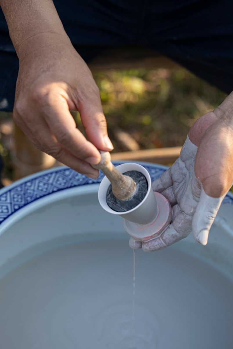 A craftsman dips a pottery ware in glaze at the Gong Hua Kiln. Photo: Courtesy of Gong Hua