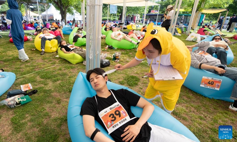 A staff member tests a competitor taking part in a sleep competition in Seoul, South Korea, May 18, 2024. A sleep competition was held at Yeouido Han River Park in Seoul Saturday to help citizens relax and experience the fun of taking nap outdoors. Photo: Xinhua