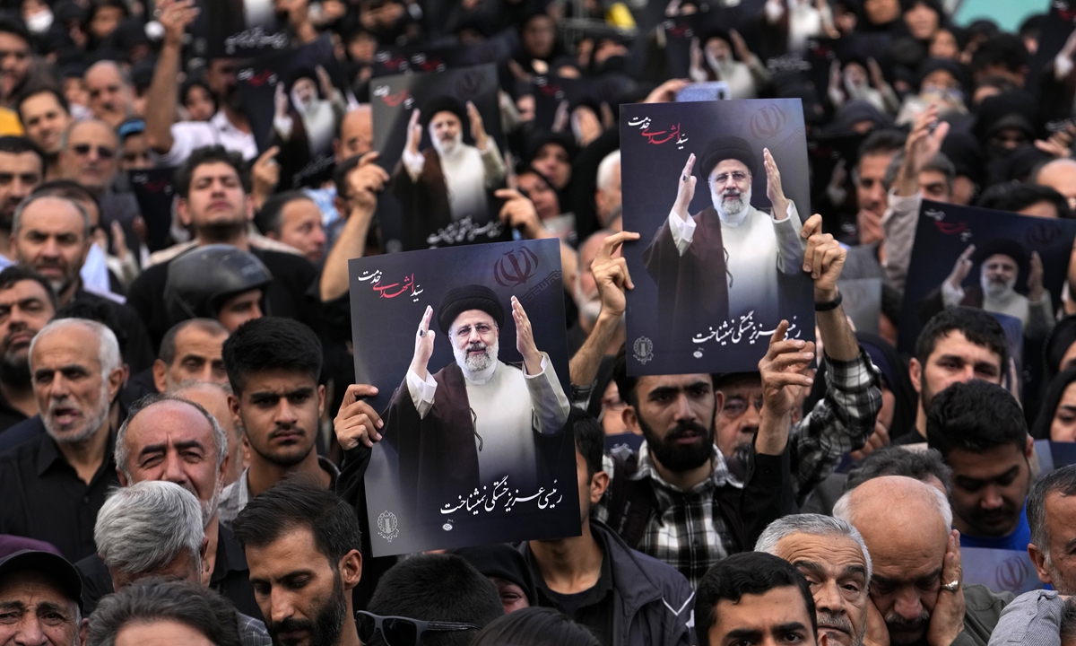 People hold up posters of President Ebrahim Raisi during a mourning ceremony for him at Vali-e-Asr square in downtown Tehran on May 20, 2024. Photo: VCG