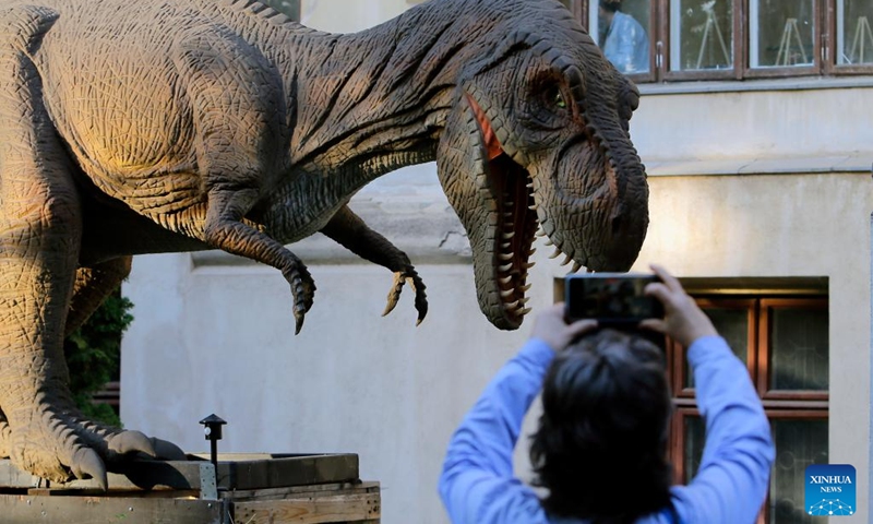 A person takes photos of a dinosaur replica at National Museum of Geology during the European Night of Museums event in Bucharest, Romania, May 18, 2024. European Night of Museums takes place on the third Saturday of May. It is a cultural event in which museums and cultural institutions remain open late into the night to introduce themselves to new potential patrons. Photo: Xinhua