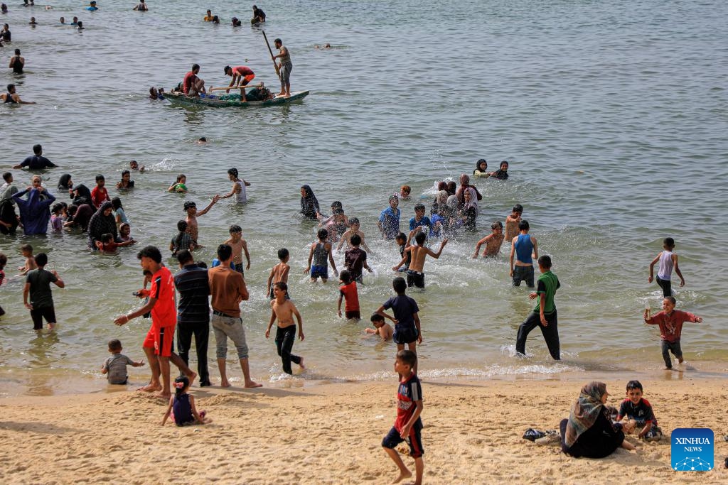 People spend time at the seaside during hot weather in the city of Deir al-Balah, central Gaza Strip, on May 20, 2024.(Photo: Xinhua)