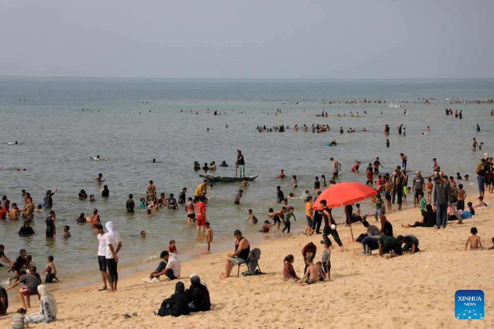 People spend time at the seaside during hot weather in the city of Deir al-Balah, central Gaza Strip, on May 20, 2024.(Photo: Xinhua)