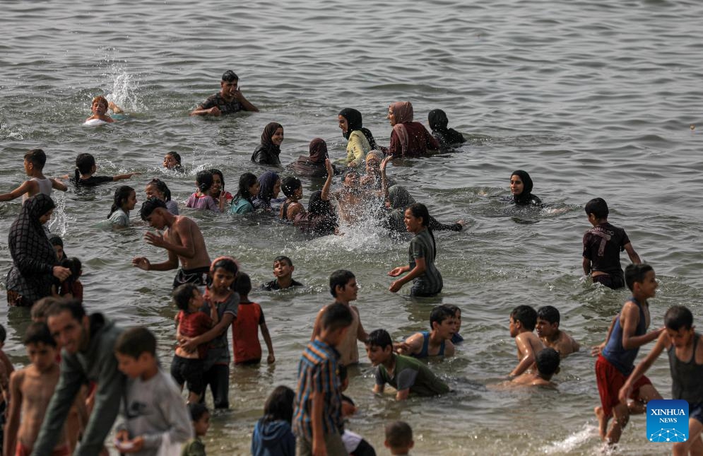 People spend time at the seaside during hot weather in the city of Deir al-Balah, central Gaza Strip, on May 20, 2024.(Photo: Xinhua)