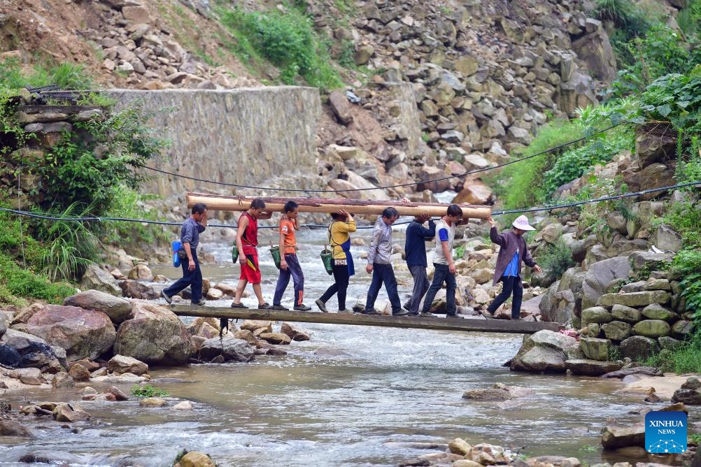 Wu Xinren (4th R) and villagers carry wood to build a wooden building in Wuying Village on the border between south China's Guangxi Zhuang Autonomous Region and southwest China's Guizhou Province, July 1, 2019.(Photo: Xinhua)