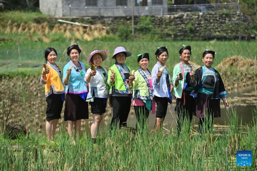 He Yuqing (2nd L) and her friends show the freshly-caught fish in Wuying Village on the border between south China's Guangxi Zhuang Autonomous Region and southwest China's Guizhou Province, Oct. 3, 2023.(Photo: Xinhua)