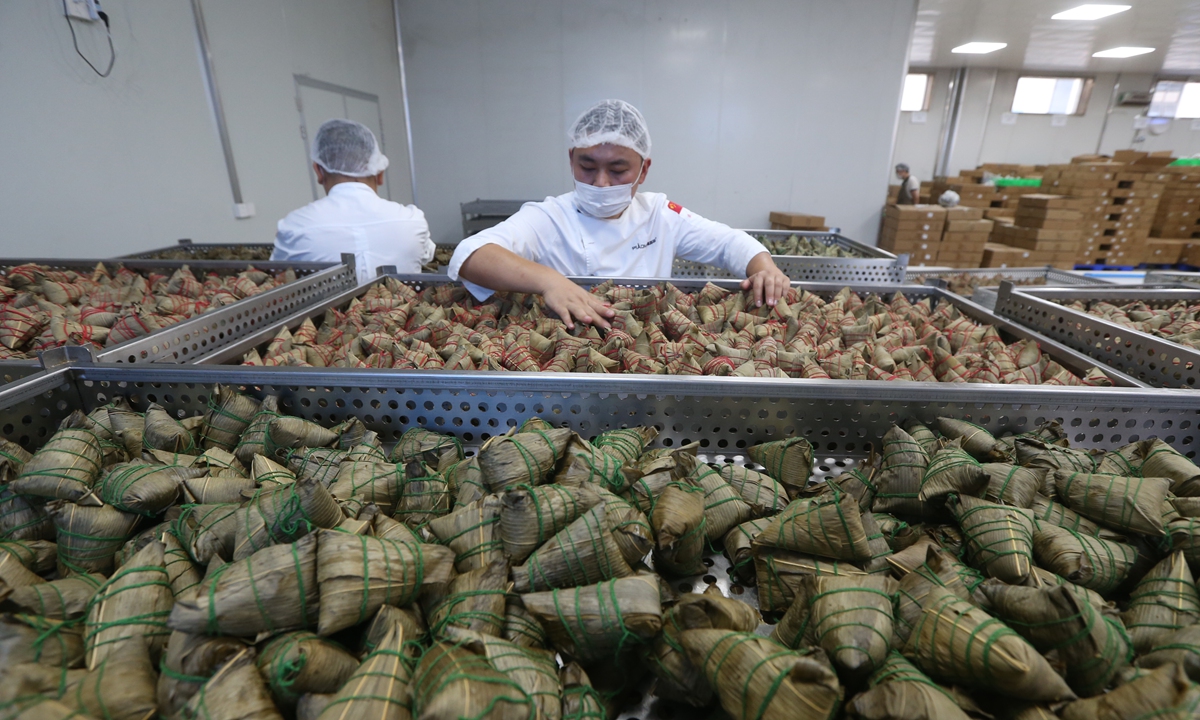 Workers prepare sticky rice dumplings, or zongzi, inside a food processing factory in Meishan, Southwest China's Sichuan Province on May 21, 2024. Zongzi is a traditional delicacy enjoyed by Chinese people during the Dragon Boat Festival, which falls on June 10 this year. Photo: VCG