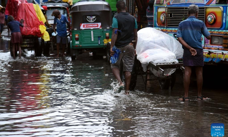 People wade through a waterlogged road in Colombo, Sri Lanka, May 21, 2024. Over 33,000 people in Sri Lanka remain affected by the adverse weather conditions, an official said on Tuesday.(Photo: Xinhua)