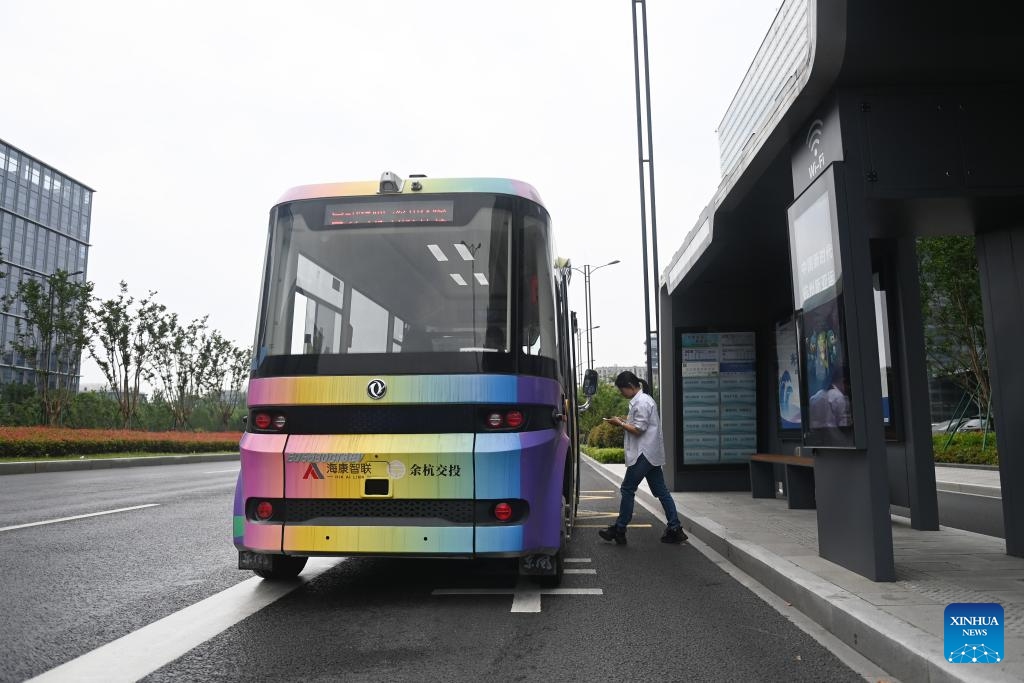A passenger gets on an autonomous driving minibus in Yuhang District, Hangzhou City, east China's Zhejiang Province, May 22, 2024. The autonomous driving bus route in Yuhang District is the first one of its kind powered by vehicle-road coordination technology in Hangzhou. This 5-kilometer bus line winds through schools, industrial parks, residential compounds and subway stations, free of charge for all citizens.(Photo: Xinhua)