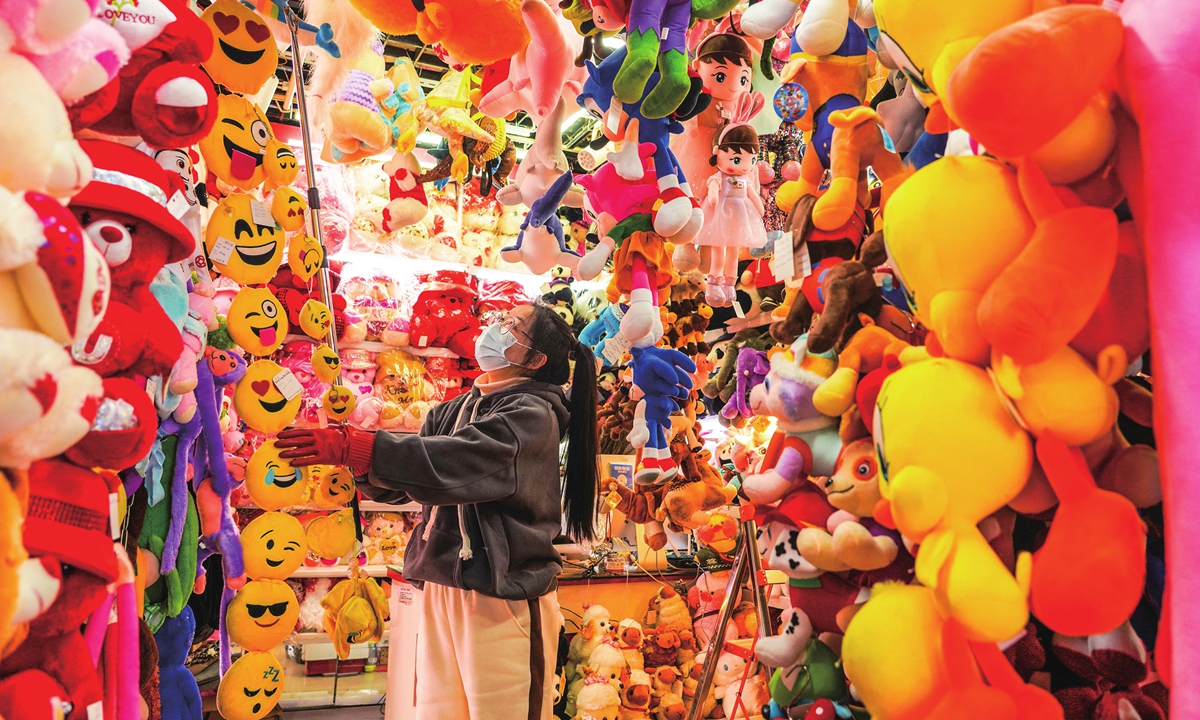 A shop employee arranges toys in the store in Yiwu. Photo: VCG