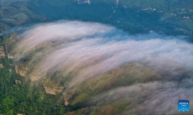 An aerial drone photo taken on May 23, 2024 shows clouds streaming down the Jinfo Mountain in Nanchuan District, southwest China's Chongqing Municipality.(Photo: Xinhua)