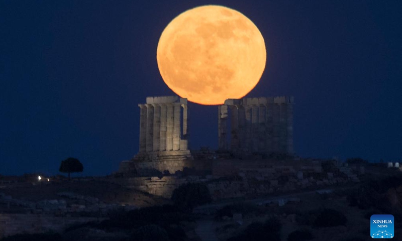 A full moon rises above the Temple of Poseidon at Cape Sounion, Greece, May 23, 2024. (Xinhua/Marios Lolos)