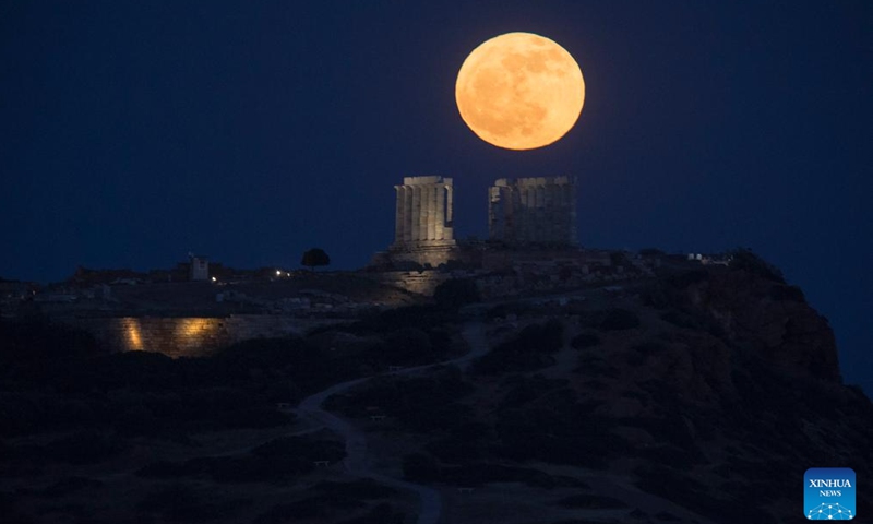 A full moon rises above the Temple of Poseidon at Cape Sounion, Greece, May 23, 2024. (Xinhua/Marios Lolos)