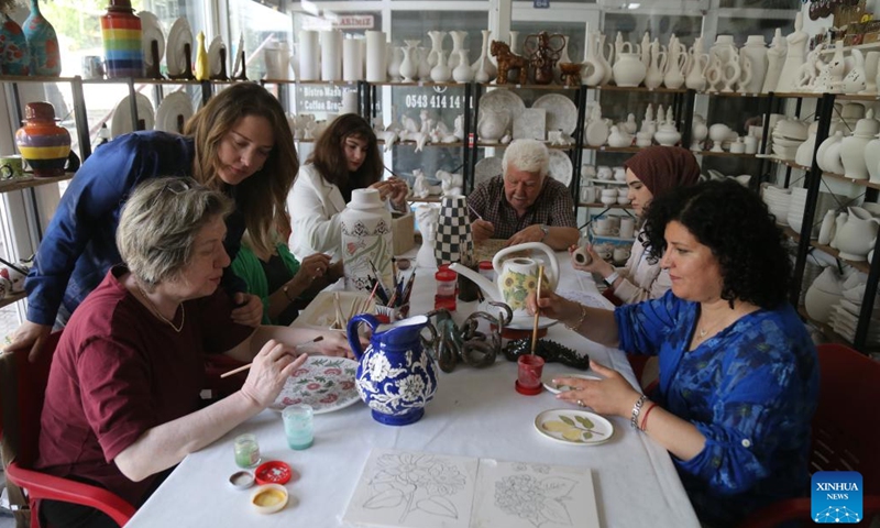 Turkish ceramist Duygu Kavukcu (2nd L) instructs her students, who are suffering from various health issues, how to mold clay and make ceramic objects in a studio in Ankara, Türkiye, on May 22, 2024. People suffering from various health issues are finding therapeutic solace offered by female Turkish ceramist Duygu Kavukcu willing to go the extra mile for those in need of inner well-being and emotional support. (Photo: Xinhua)