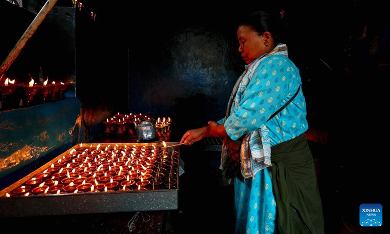 A devotee lights oil lamps to mark Buddha Jayanti at the Swayambhunath Stupa in Kathmandu, Nepal, May 23, 2024. Every year, Buddha Jayanti is celebrated on the full moon day in the Nepali month of Baishakh marking Buddha's birth, attainment of enlightenment and his death.(Photo: Xinhua)