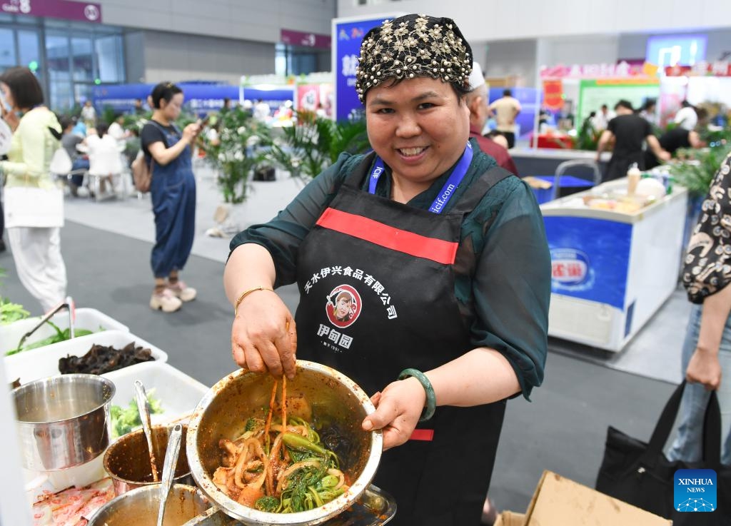 An exhibitor from Tianshui of Gansu Province shows the malatang, literally meaning a numbingly spicy hotpot, during the 20th China (Shenzhen) International Cultural Industries Fair (ICIF) at the Shenzhen World Exhibition and Convention Center, Shenzhen, south China's Guangdong Province, May 23, 2024. The 20th ICIF opened here on Thursday. According to the organizers, the five-day event held offline and online simultaneously has attracted over 6,000 government entities, cultural organizations and enterprises, with more than 120,000 exhibits on display.(Photo: Xinhua)