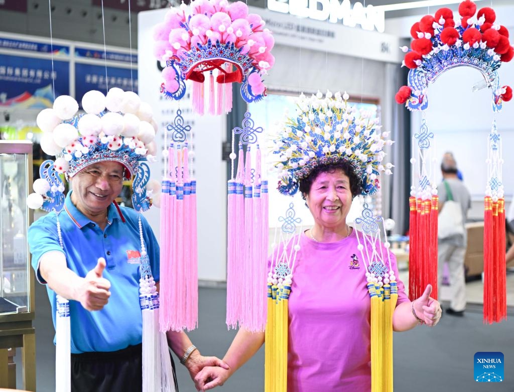 Visitors pose for photos with tradtional opera headwear during the 20th China (Shenzhen) International Cultural Industries Fair (ICIF) at the Shenzhen World Exhibition and Convention Center, Shenzhen, south China's Guangdong Province, May 23, 2024. The 20th ICIF opened here on Thursday. According to the organizers, the five-day event held offline and online simultaneously has attracted over 6,000 government entities, cultural organizations and enterprises, with more than 120,000 exhibits on display.(Photo: Xinhua)