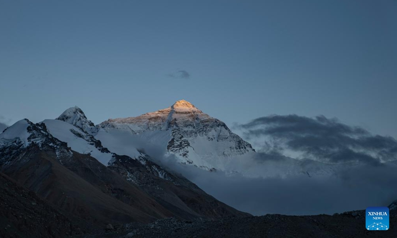 This photo taken on May 23, 2024 shows a view of the Mount Qomolangma at sunset in southwest China's Xizang Autonomous Region. The Mount Qomolangma National Park has entered peak tourism season. From Jan. 1 to May 20 this year, the Mount Qomolangma scenic spot has received about 136,000 tourists. (Photo:Xinhua)