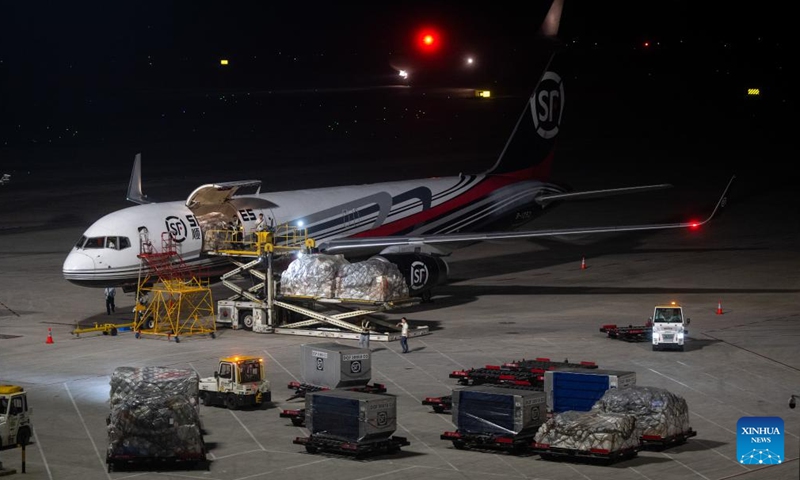 Staff members load the cargo onto an airplane at the Ezhou Huahu Airport in Ezhou, central China's Hubei Province, May 25, 2024. The Ezhou Huahu Airport, an all-cargo hub airport starting operations in July 2022, is now running 48 domestic routes and 17 international routes. The airport owns a 750,000-square meter cargo transfer center with parcel sorting lines adding up to 52 kilometers, and its international throughput has exceeded 80,000 tonnes. (Photo:Xinhua)